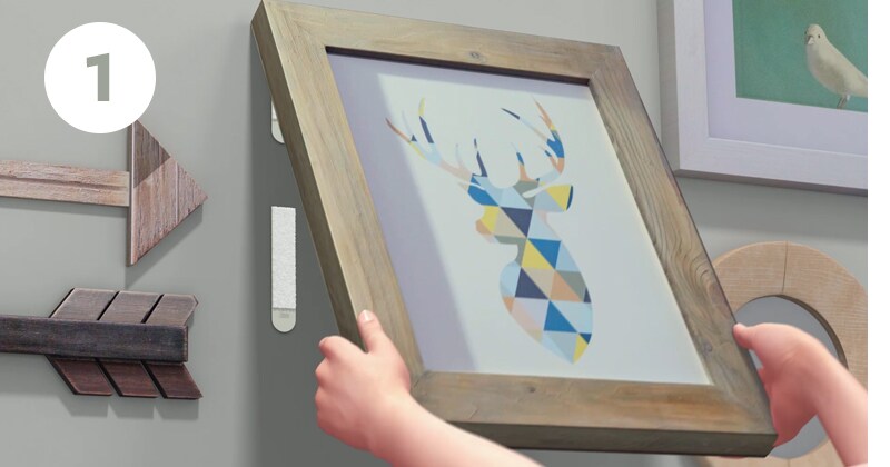 Step 1 of how to remove picture hangers - grab bottom corners and peel frame from wall
